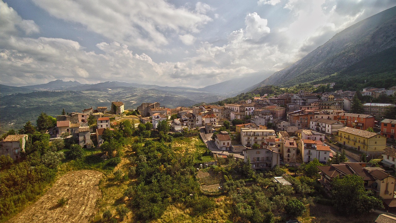 Panorama mozzafiato di un piccolo paese calabrese affacciato sul mare e circondato da colline verdi.