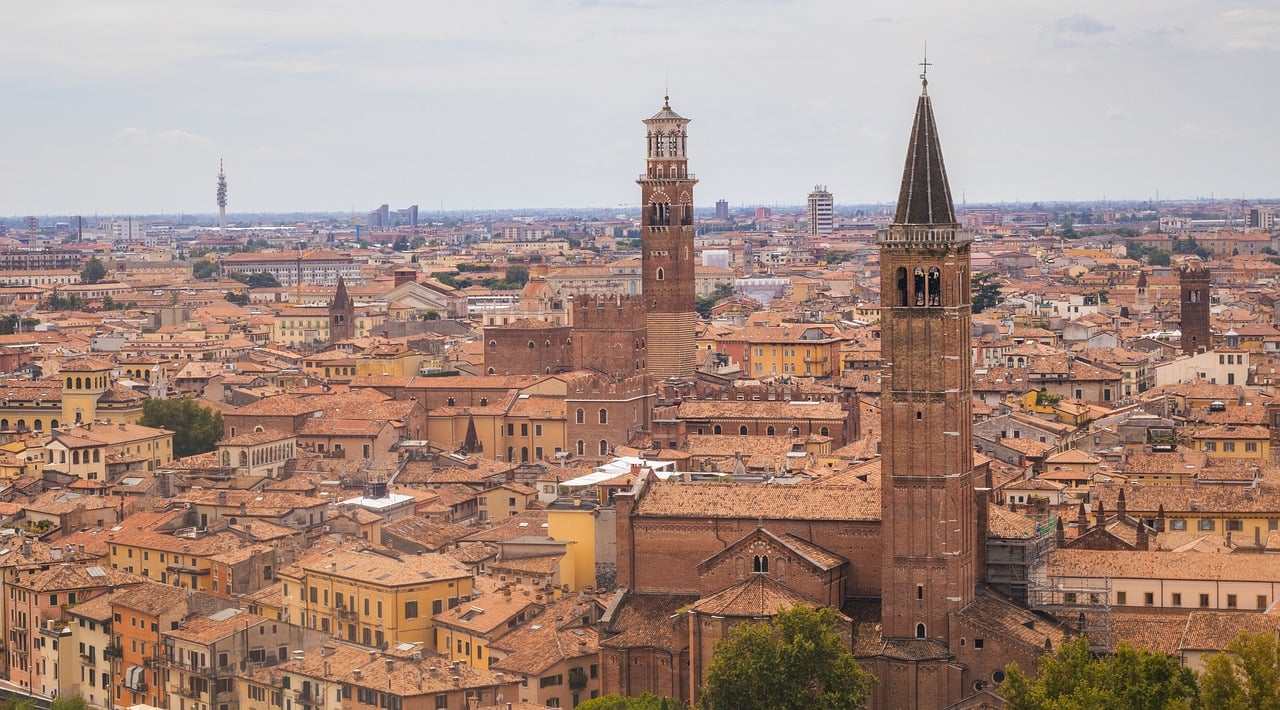 Panorama mozzafiato di Verona dall'alto, con il centro storico e l'Arena visibili in lontananza.