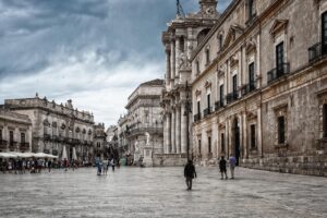 Vista panoramica di Ortigia, con il mare blu e antichi edifici storici.