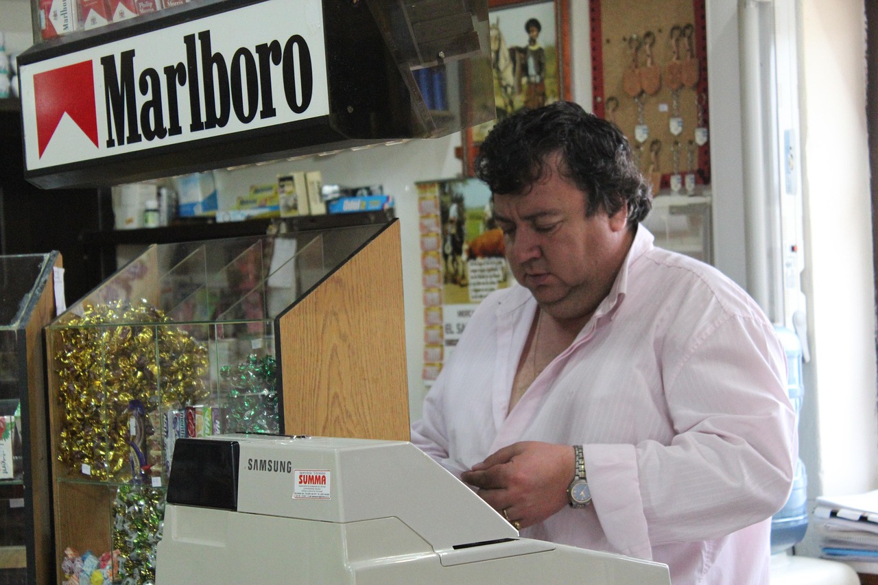 Immagine di un tabaccaio con biglietti Gratta e Vinci in esposizione e un cliente intento a scegliere.