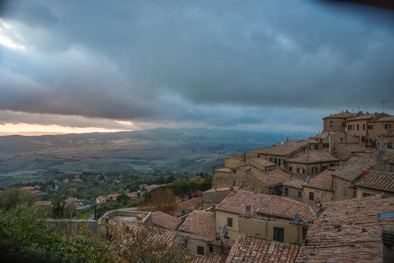 Calice di vino rosso sotto un cielo al tramonto nel suggestivo paesaggio toscano.