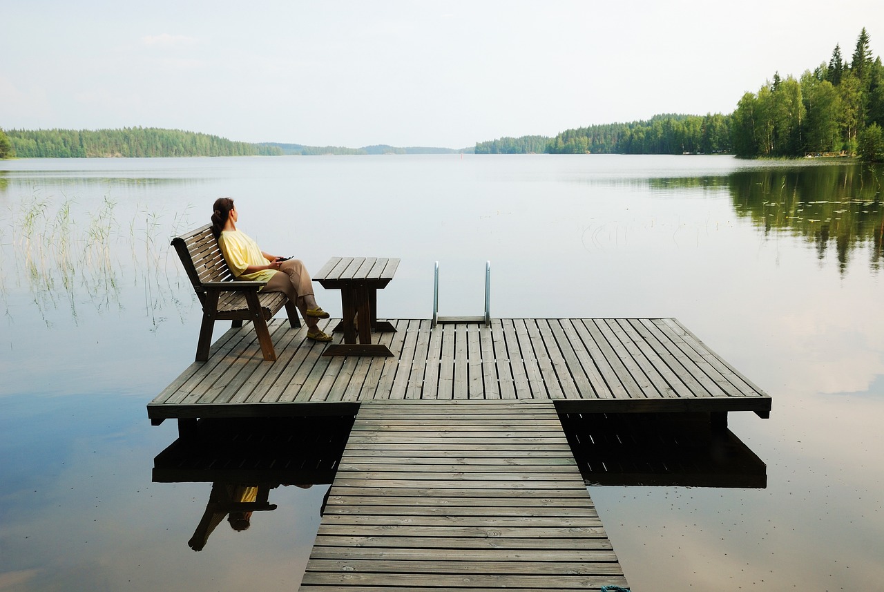Vista panoramica di un lago tranquillo circondato da natura, ideale per il relax e la meditazione.
