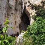 Vista panoramica della grotta azzurra in Salento, con acqua cristallina e pareti rocciose.