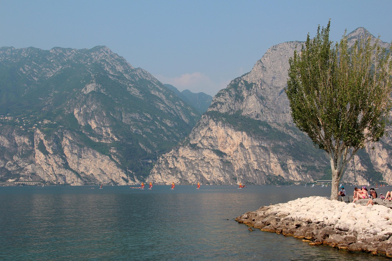 Lago italiano con acque blu e scogliere, simile a un fiordo norvegese, circondato da montagne verdi.