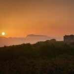 Panorama mozzafiato di un paese sardo, con case colorate e mare cristallino che ricorda un set cinematografico.