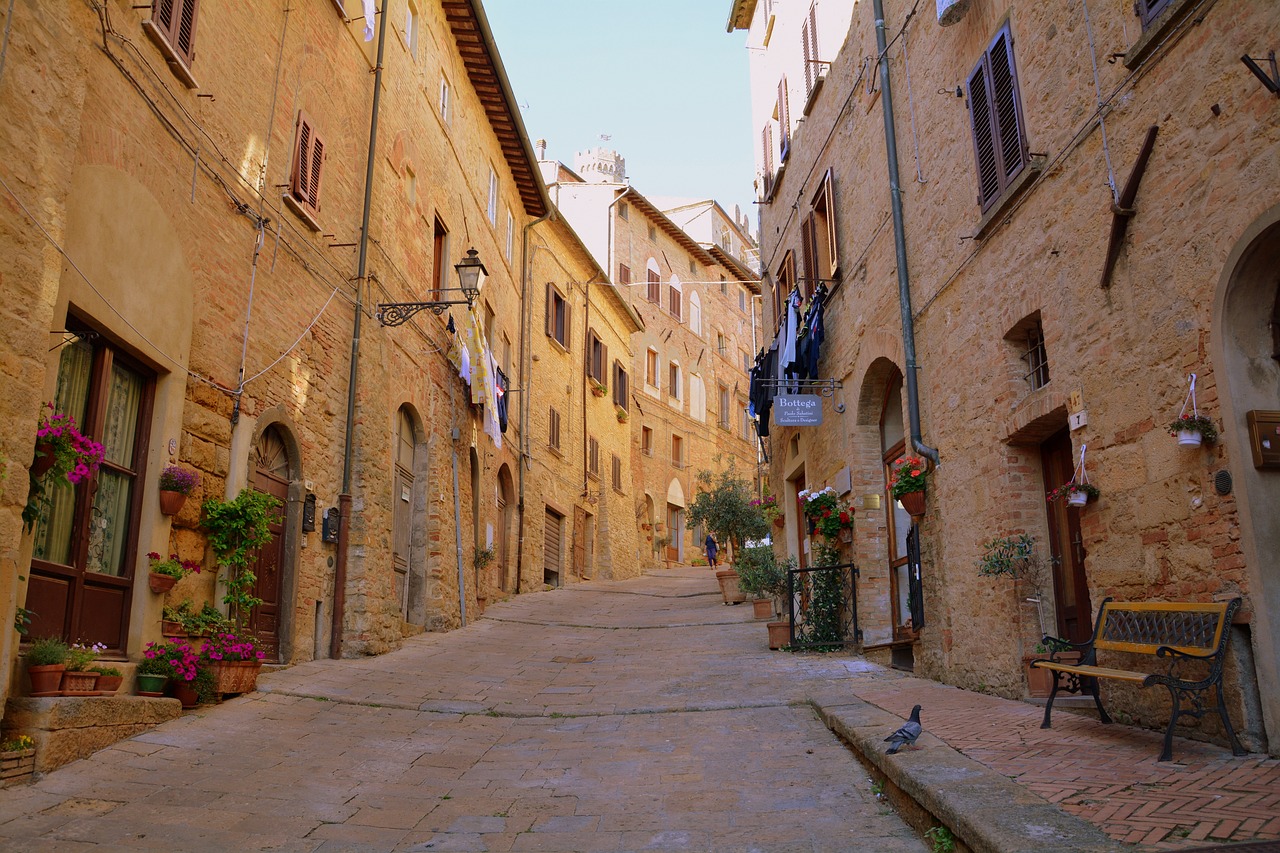 Scorcio panoramico di una pittoresca città toscana con strade acciottolate e edifici storici.