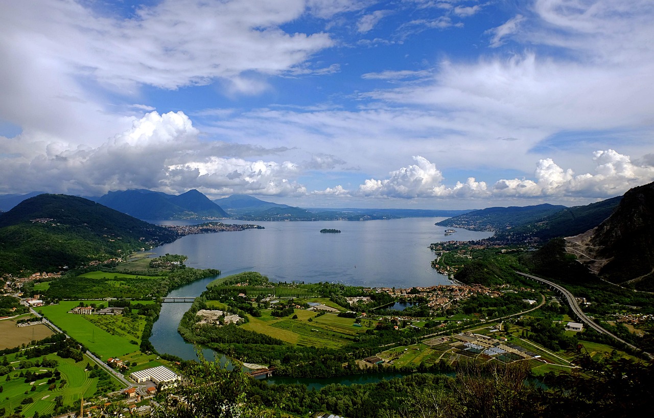 Panorama del paese lombardo con colline verdi e antiche costruzioni storiche.