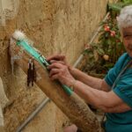 Borgo abruzzese con artigiani intenti a realizzare merletti a tombolo, simbolo di tradizione e arte locale.
