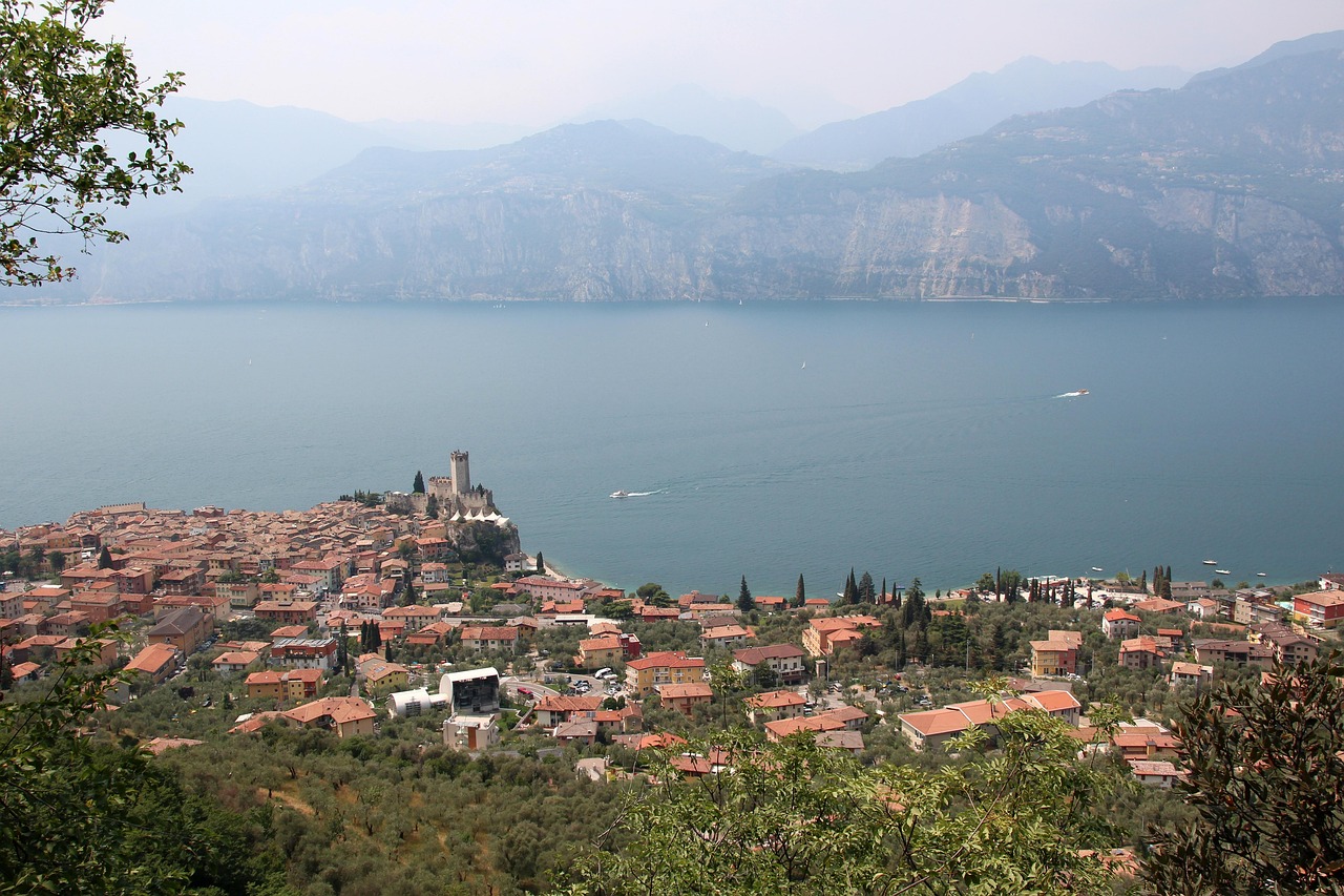 Borgo medievale panoramico sul lago, con antiche costruzioni e natura circostante.