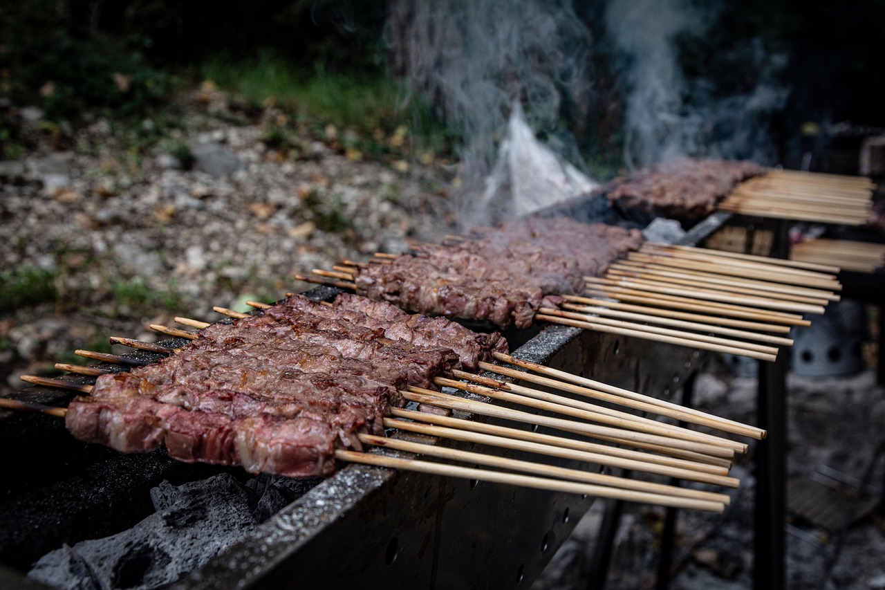 Arrosticini serviti in un tipico ristorante del borgo abruzzese, con sfondo di paesaggio montano.