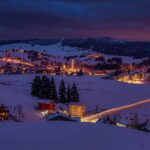Paesaggio incantato del Trentino con mercatini di Natale e decorazioni festive.