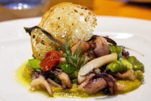Piatti di pesce fresco serviti in un ristorante con vista sul mare della Sardegna.
