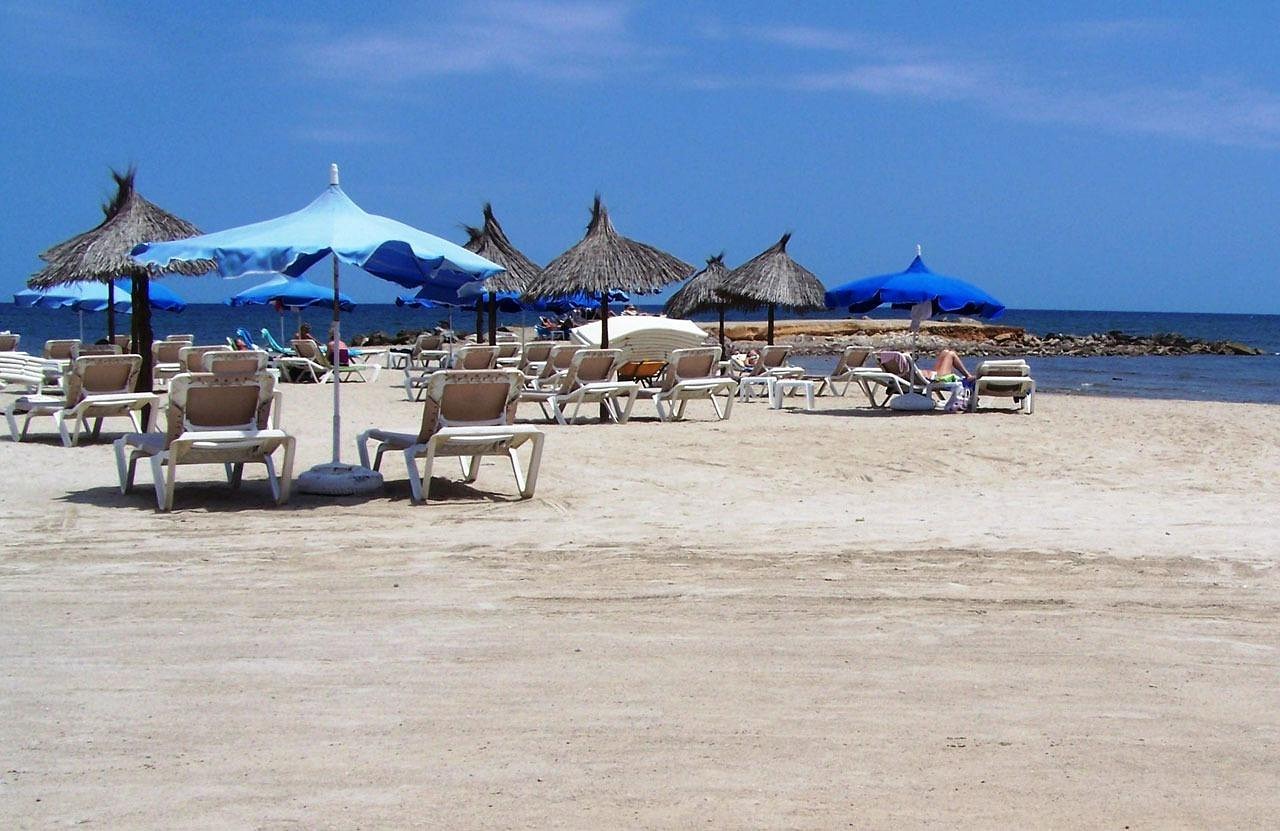 Viaggiatori felici in un mercato locale, circondati da prodotti a buon prezzo.