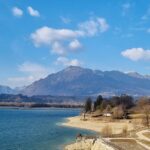 Lago incantevole del Friuli, circondato da montagne verdi e cielo sereno.