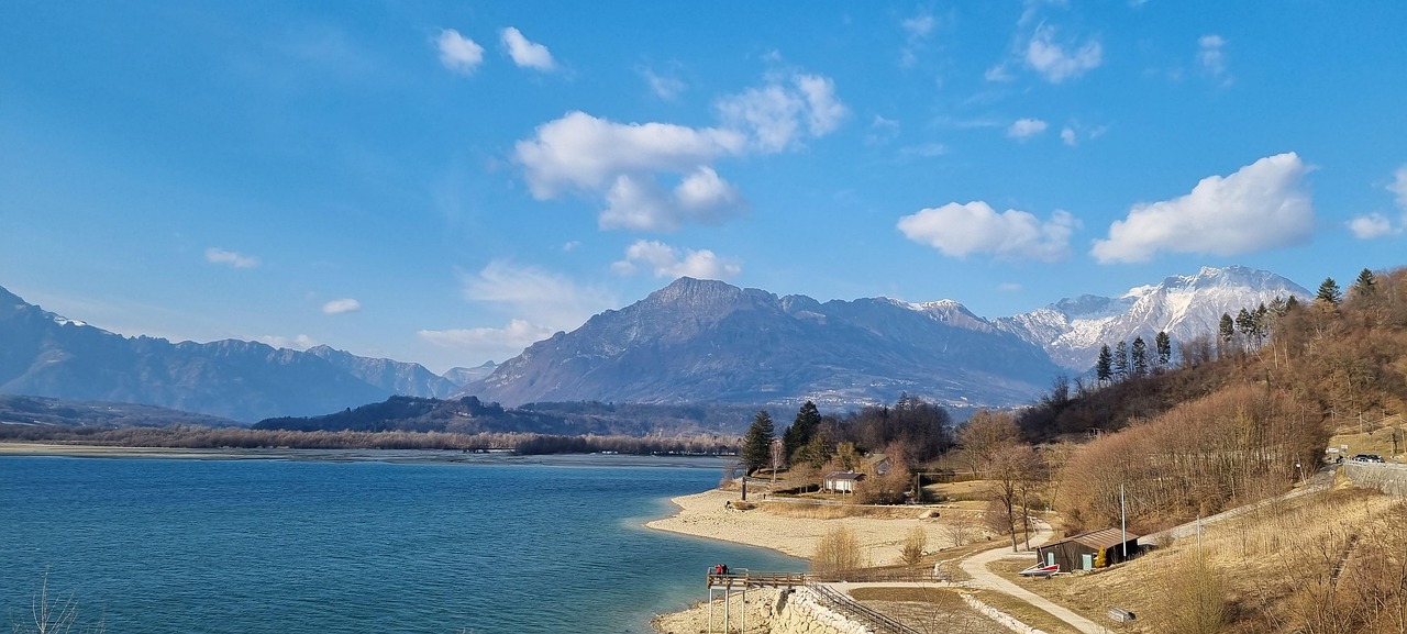 Lago incantevole del Friuli, circondato da montagne verdi e cielo sereno.