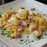 Tortellini serviti in una trattoria tipica di Bologna, con un'atmosfera accogliente e tradizionale.