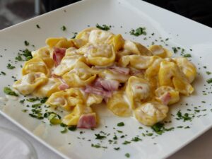 Tortellini serviti in una trattoria tipica di Bologna, con un'atmosfera accogliente e tradizionale.