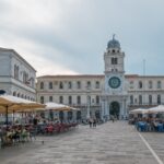 Piazza storica di una città veneta, con architettura suggestiva e atmosfera vivace.