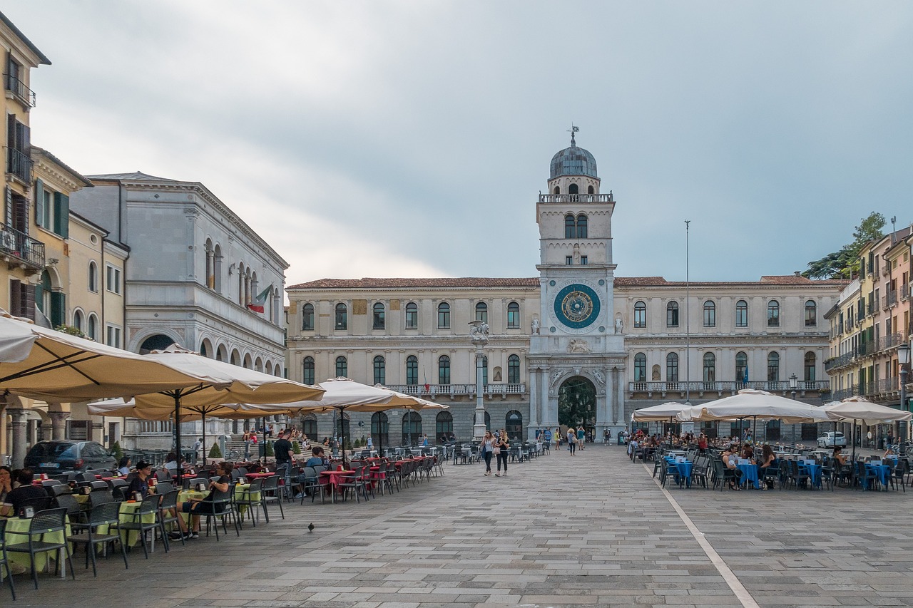 Piazza storica affollata a Venezia, circondata da eleganti edifici e monumenti.