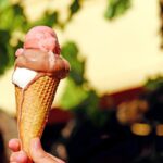 Gelato artigianale cremoso e colorato servito in una coppa nel centro di una città marchigiana.