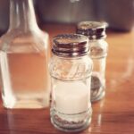 Un bicchiere di acqua con aceto su un tavolo, simbolo di un rimedio naturale per la digestione.