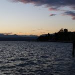 Panorama mozzafiato del lago veneto al tramonto, con colori caldi e riflessi sull'acqua.
