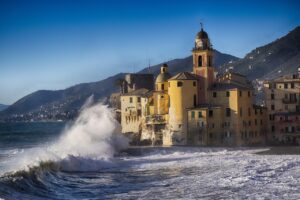 Vista panoramica del villaggio ligure sul mare, con case colorate e il blu intenso dell'acqua.