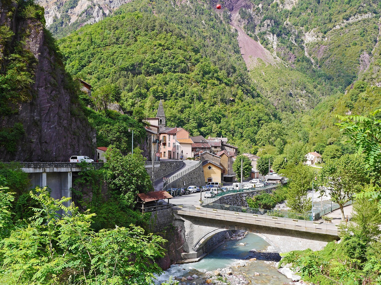 Panorama di un pittoresco paese italiano con stradine acciottolate e case colorate, simile a una cartolina vintage.