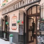 Mercato rionale di Torino con bancarelle che espongono piatti tipici locali e prodotti freschi.