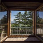 Coppia felice che si abbraccia in una romantica casa sull'albero in Toscana.