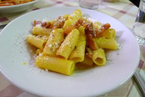 Piatto di carbonara servito in una trattoria romana, con guanciale croccante e pecorino.