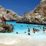 Spiaggia affollata con turisti felici, meta di vacanza popolare dell'anno.