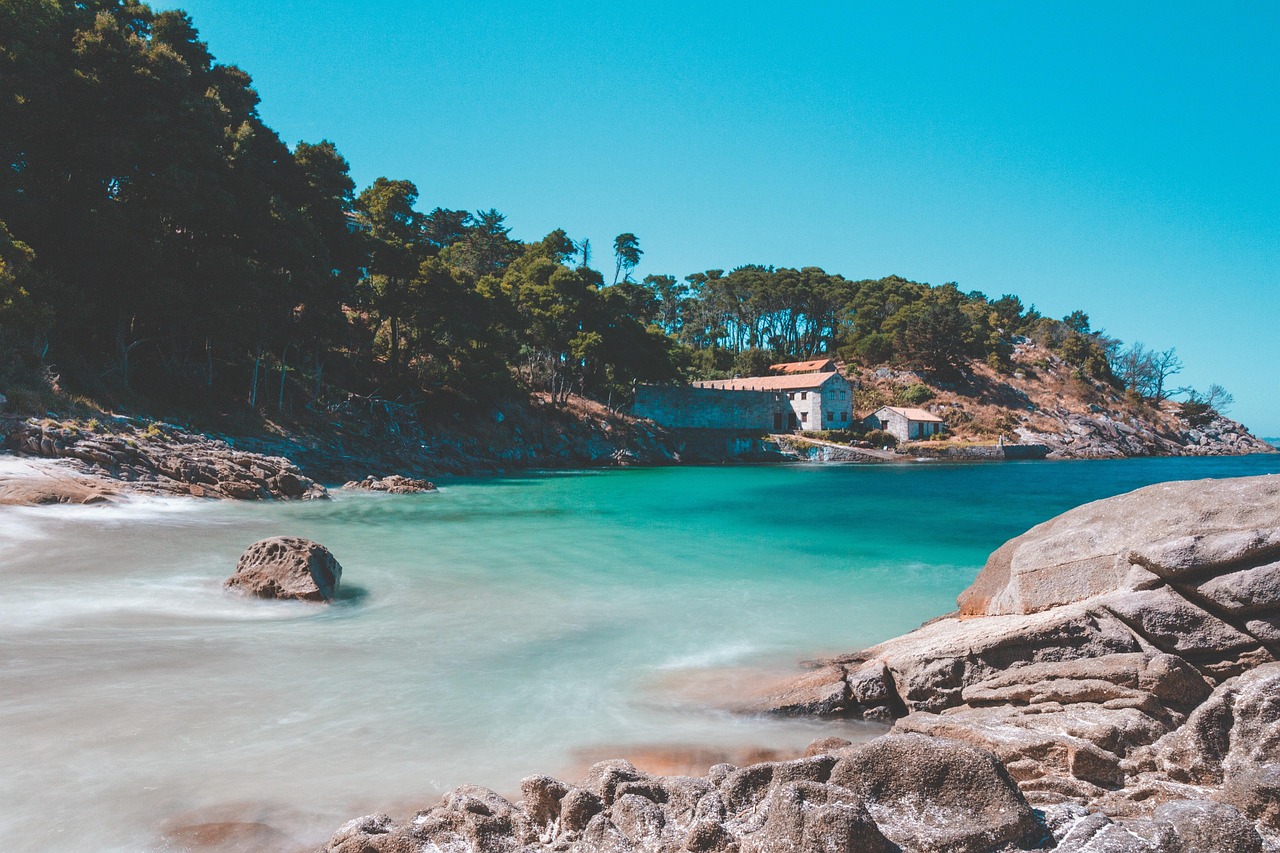 Spiaggia di sabbia dorata con acque turchesi e scogliere a picco sul mare in una località francese.
