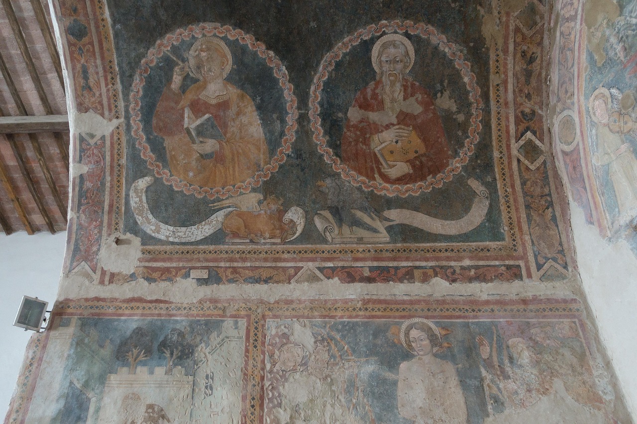 Chiesa toscana con affreschi antichi, immersa nella campagna, simbolo di arte e storia dimenticata.