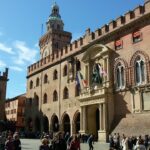 Piazza storica di Bologna con antichi edifici e atmosfera suggestiva, simbolo di leggende locali.