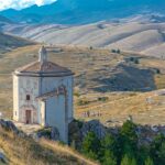 Sentiero panoramico in Abruzzo con vista mozzafiato su montagne e valli circostanti.
