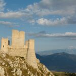 Vista panoramica delle torri medievali di Pacentro con il borgo e le montagne sullo sfondo.