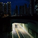 Panoramica di una città tranquilla, con persone che passeggiano lentamente in un ambiente sereno.