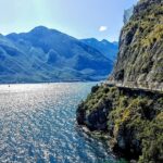Vista panoramica di Limone sul Garda con la ciclabile sospesa e limoni in primo piano.