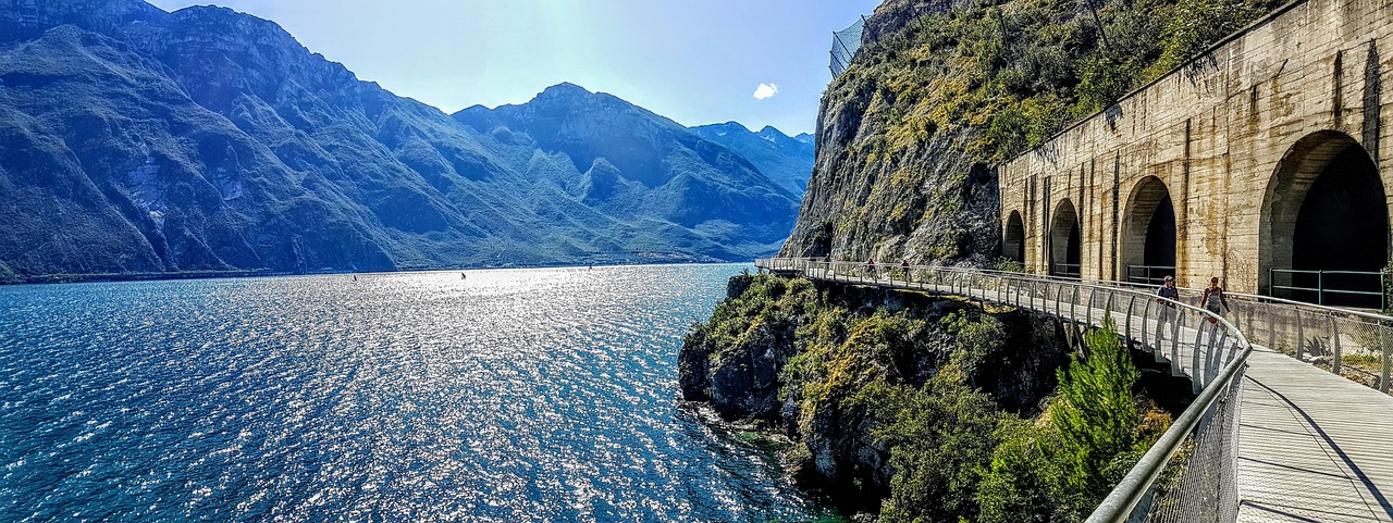 Vista panoramica di Limone sul Garda con la ciclabile sospesa e limoni in primo piano.