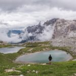 Panorama mozzafiato delle Dolomiti lungo un sentiero nascosto, tra rocce e vegetazione.