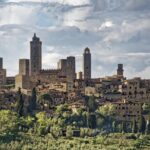 Vista panoramica di San Gimignano con le torri medievali e il paesaggio toscano sullo sfondo.